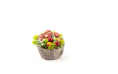 Obraz premium Artificial mushrooms and flowers in a basket with burlap.