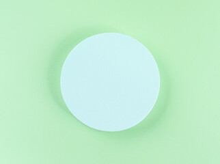 Round geometric shape turquoise podium for product display and text on green background