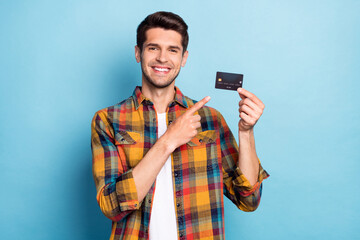 Portrait of attractive cheerful guy holding in hand demonstrating bank card deposit isolated over...