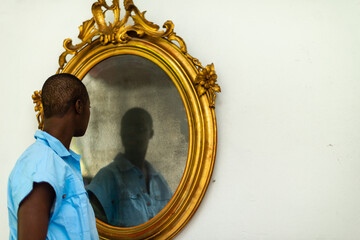 short haired african woman looking herself in the mirror