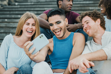 Young friends doing selfie with mobile phone outdoor in the city - Focus on gay man face
