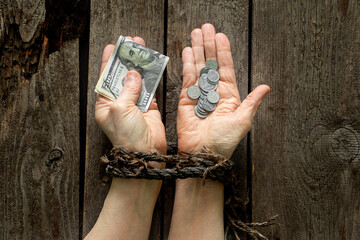 in one hand dollars in the other hand Ukrainian pennies in hands tied with a rope on a table