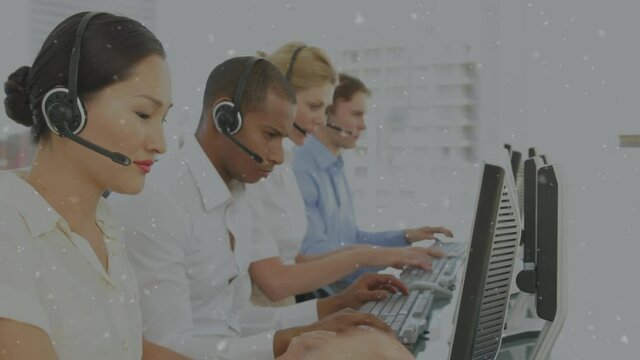 White particles floating against team of customer care executives working at office
