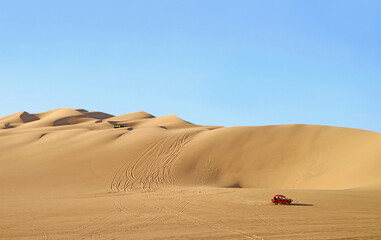 Fototapeta na wymiar Dune buggies running on the amazing Huacachina sand dunes in Ica region, Peru, South America