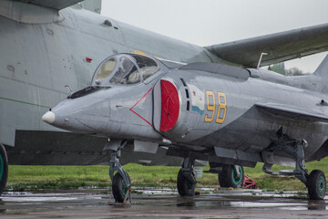 A Soviet fighter with a vertical take-off function, wet from the rain, stands in an aviation parking lot