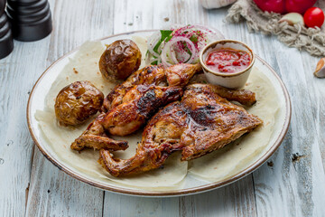 fried chicken tobacco with sause on plate on white wooden table