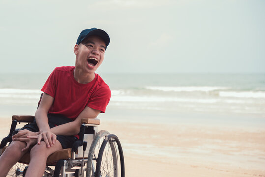 Asian Happy Disabled Teenage Boy, Activity Outdoors With Family On The Beach Background, People Having Fun And Diverse People Concept.