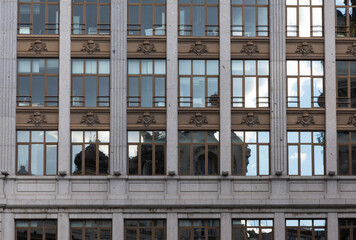 facade of an old buildingwith reflections of buildings in the windows . Backgrounds