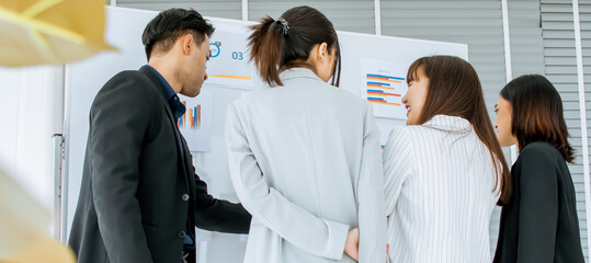 Fototapeta na wymiar Banner of mixed gender Asian businesspeople standing, working, brainstorming together, planing and thinking about business creative marketing idea on white board in modern indoor office.