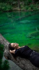 Girl relaxing in the forest next to the lake