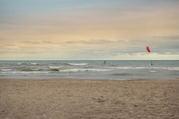 Obraz premium kitesurfing on beach with sunset