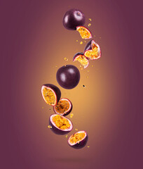 Whole and sliced fresh passion fruit (passiflora) in the air on a purple background