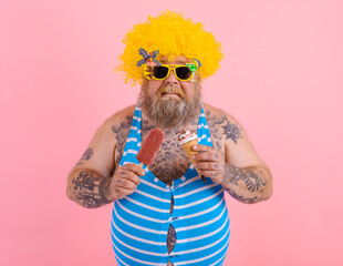 Fat man with beard and wig eats a popsicle and an icecream