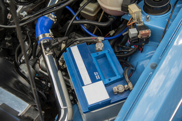 Fototapeta premium Open hood of a vintage car. Battery brake and coolant reservoir