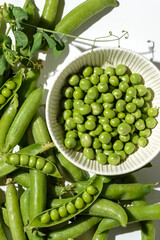 green peas and pods on a white background