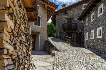 A cobbled street and alpine houses in Pontechianale, a charming village in Varaita Valley,...
