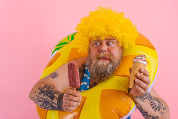 Fat man with beard and wig eats a popsicle and an icecream