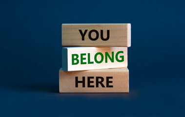 You belong here symbol. Wooden blocks with words 'You belong here' on beautiful grey background....