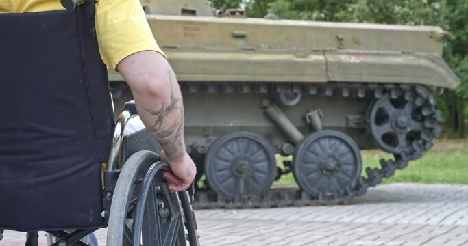 Young man in wheelchair near tank outdoors