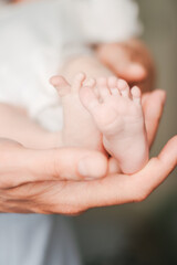 Obraz na płótnie Canvas Soft focus close-up of newborn baby feet. Hands of a father holding baby feet.