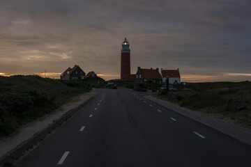 red lighthouse with some houses on the Waddenisle of texel