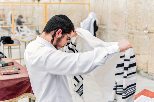 Young Orthodox Jewish man praying in the morning at the Western Wall.