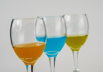 Wine glasses with yellow, blue and orange wine