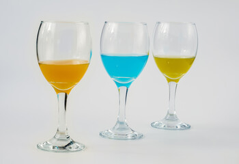Wine glasses with yellow, blue and orange wine