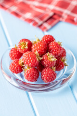 Ripe red raspberries on glass plate