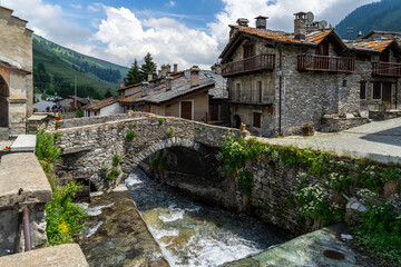 The Varaita river passing under old stone bridge in the village of Chianale, Varaita Valley, Piedmont, Italy