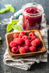 Ripe raspberries in bowl and raspberry jam.