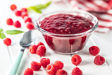 Red rasberries jam in bowl and ripe raspberries.