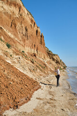 back view of a young woman and backpack walks alone