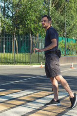 Middle-aged man walking at the crosswalk on a street and showing stop gesture with his hand.