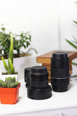 Photographic camera lenses on a desk, with a white background.