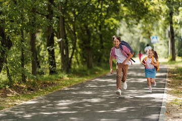 Primary school pupil. boy and girl with backpacks walking down the street. Happy children happy to go back to school. beginning school year. Kids are happy to run to school. School education.