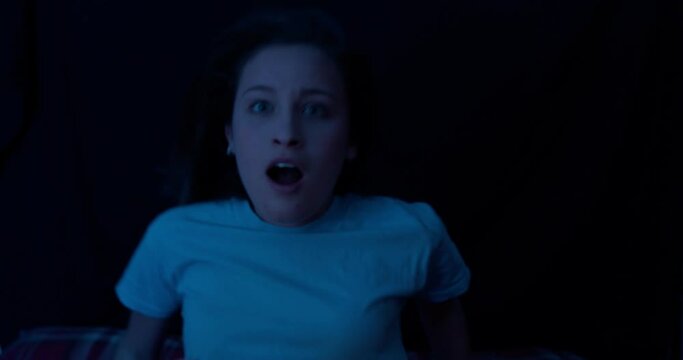 nightmare, bad dream - young woman wakes up terrified of a nightmare