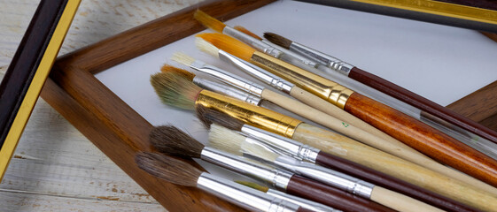 Fototapeta premium image of painting brushes and frames on a white background close-up