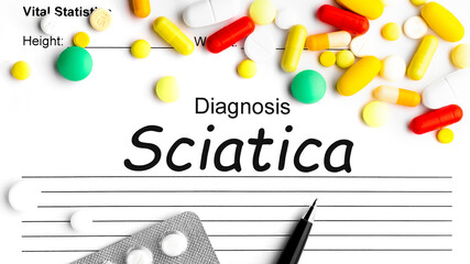 Word SCIATICA on paper, assorted pharmaceutical medicine pills, tablets and capsules.