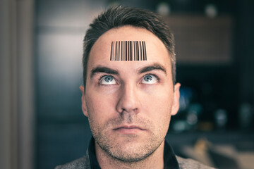 young man with a qr code on his forehead. A man with a stupid expression looks at his qr code on...
