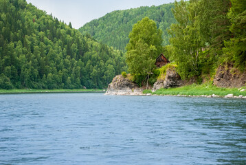 Obraz premium Landscape of Siberia. Kiya River, mountain banks and green forests in the Kemerovo region. Daytime landscape with blue skies and clouds.