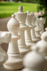 Outdoor chess board with big plastic pieces. Outdoor giant chess in public area zone, Close up big pieces of street chess in the park.