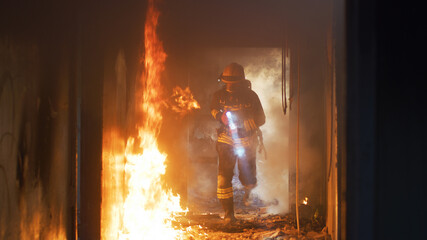 Fireman examining burning corridor during rescue mission - obrazy, fototapety, plakaty