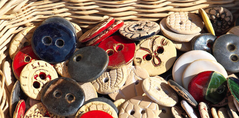 Various ceramic buttons in a wicker basket.