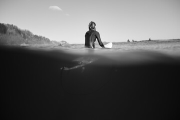 Surfista sentada esperando las olas