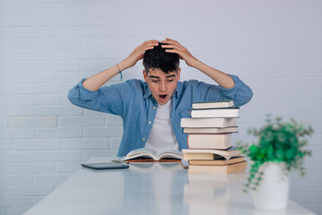 student at the desk with books and expression of astonishment or surprise