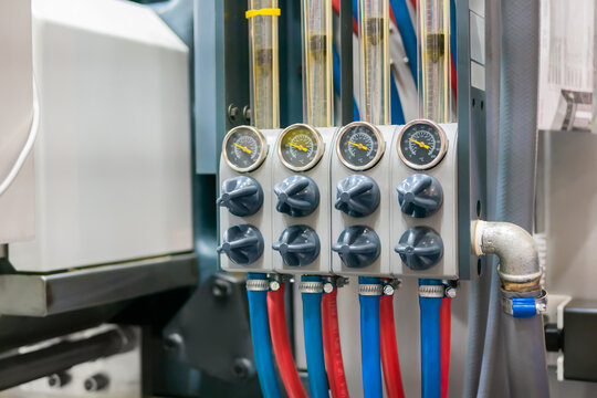 Flowmeter, rotameter - water flow regulator for cooling system of injection moulding machine at plant, factory - close up. Measuring and control equipment concept