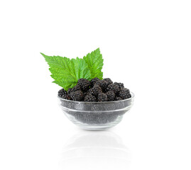 Blackberry berries with green leaves in bowl isolated on white background. Blackberry harvest