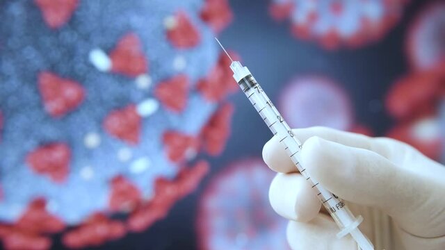 Hand holding syringe or injection of 
 Covid-19 vaccine. after making a vaccination shot in the shoulder of patient. Corona virus in the background moving. beautiful shot of medical doctor with glove