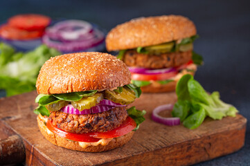 Homemade plant based burger made from sweet potato, black beans and brown rice on a whole wheat brioche bun; copy space